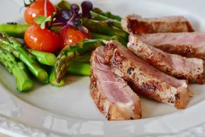 meat asparagus and tomatoes on plate